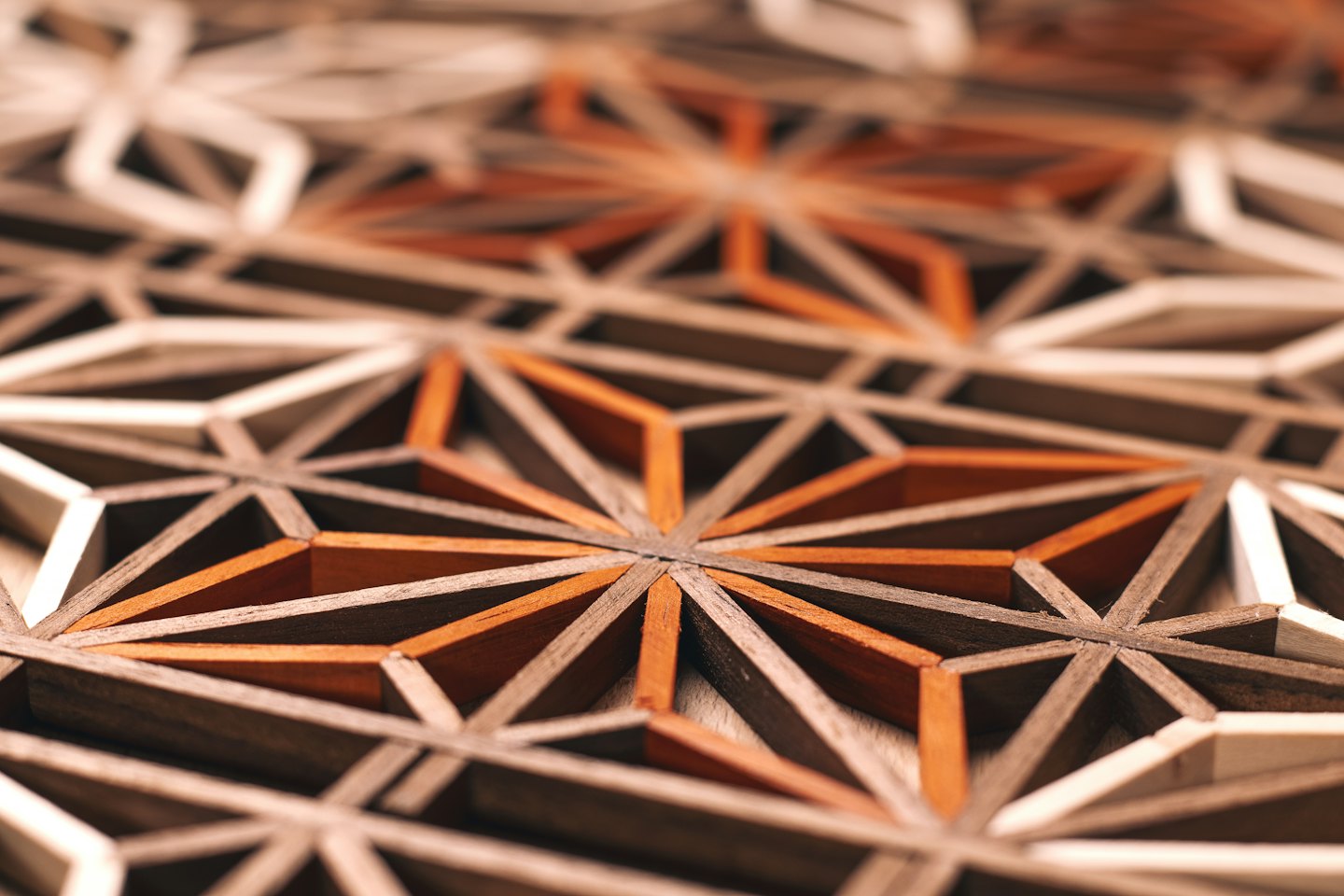 Kompliziertes hölzernes geometrisches Muster mit ineinandergreifenden Formen.
