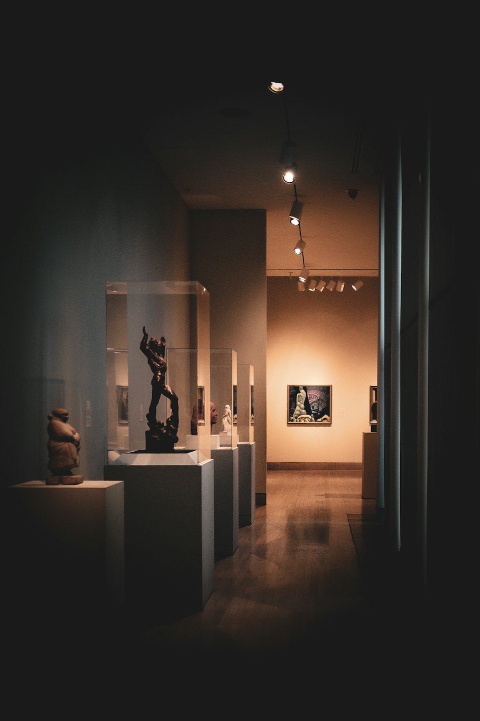 Flur einer Kunstgalerie mit Skulpturen und einem Gemälde.
